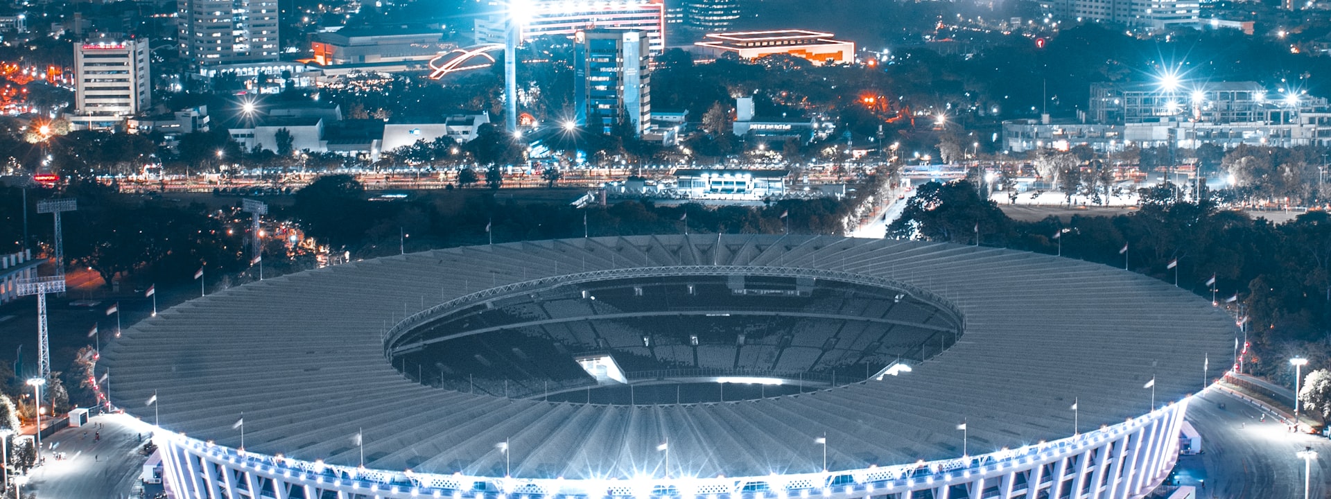 Stade éclairé par les projecteurs pendant une rencontre en soirée